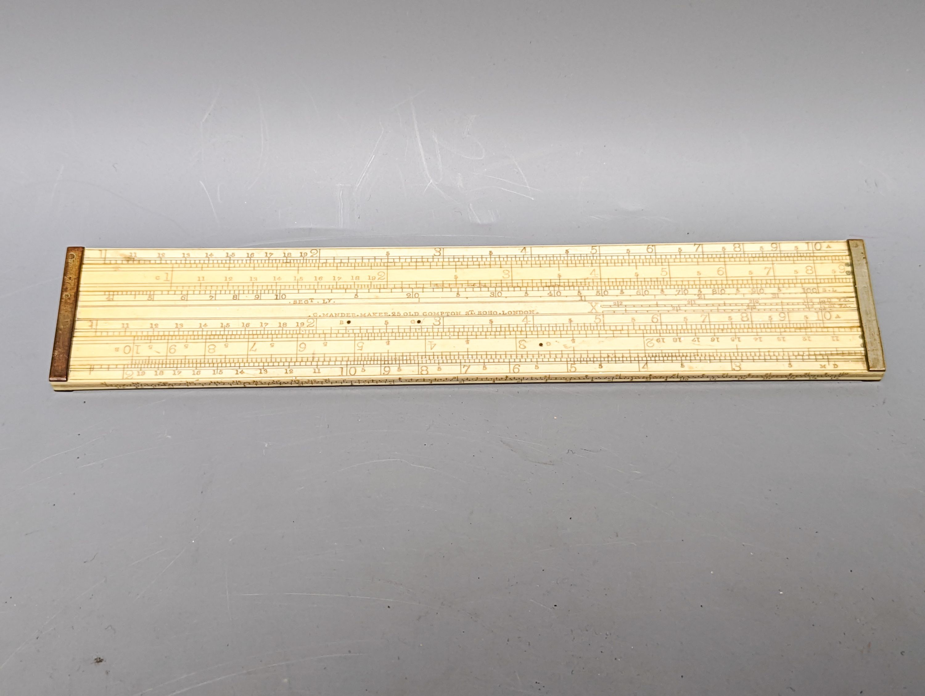 A Victorian ivory slide rule, by G. Manner, 25 Old Compton Street Soho London, 24cm, a nutmeg grater and a meat skewer